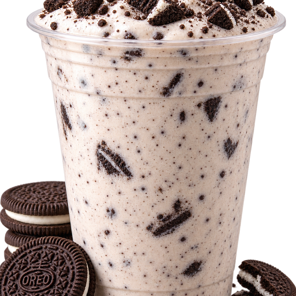 Cookies-and-cream dessert topped with chocolate sandwich cookie pieces in a clear cup, surrounded by whole and broken cookies.